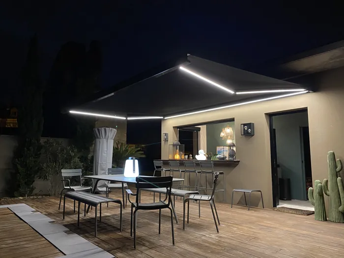 Pergola bioclimatique éclairée de nuit avec salon de jardin