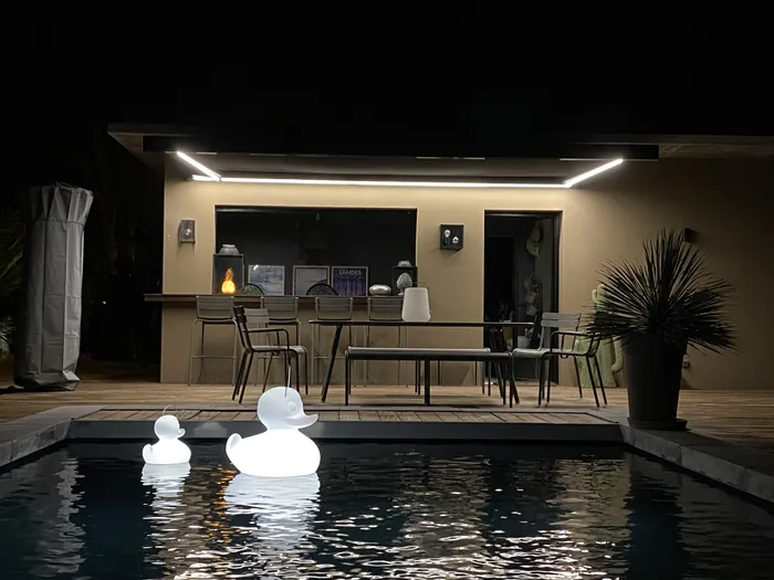 Pergola éclairée au bord d'une piscine, la nuit